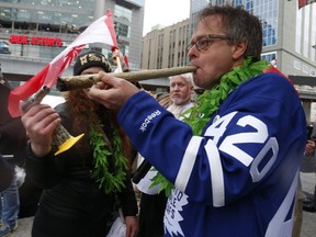 The Prince of Pot - Marc Emery - gets help firing up a huge joint during  4/20 celebrations at Yonge-Dundas Square on Thursday, April 20, 2017.