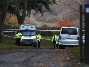 Police patrol the area near the scene of a mid-air collision between a helicopter and an aircraft, in Aylesbury, Buckinghamshire, England, Friday Nov. 17, 2017. A "number of casualties" were reported, authorities said. (Aaron Chown/PA via AP)