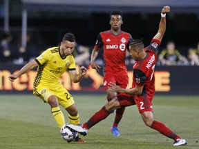 Toronto FC defender Justin Morrow (2) kicks the ball away from Columbus Crew midfielder Niko Hansen (28) during the first half of an MLS soccer match Saturday, April 15, 2017, in Columbus, Ohio. (Fred Squillante/Columbus Dispatch via AP)