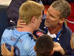 Sydney FC's Matt Simon is grabbed by Adelaide United manager Marco Kurz during a mini brawl Tuesday night.