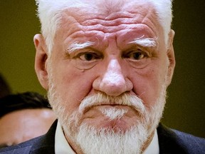 Slobodan Praljak enters the Yugoslav War Crimes Tribunal in The Hague, Netherlands, Wednesday, Nov. 29, 2017, to hear the verdict in the appeals case. The hearing was suspended after Praljak claimed to have drunk poison and shouted that he was not a war criminal, after his 20-year sentence was upheld. A United Nations war crimes tribunal handed down its last judgment, in an appeal by six Bosnian Croat political and military leaders who were convicted in 2013 of persecuting, expelling and murdering Muslims during Bosnia's war in the tribunal's last case. (Robin van Lonkhuijsen,Pool Photo via AP)