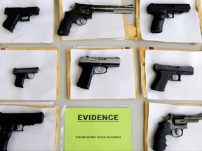 In this July 7, 2014 file photo, Chicago police display some of the thousands of illegal firearms confiscated during the year.