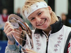 In this Nov. 17, 1996 file photo, Jana Novotna, of the Czech Republic, is all smiles after taking home a $79,000 cheque from the Advanta Tennis Championship in Villanova, Pa.  (AP Photo/Jim Graham)