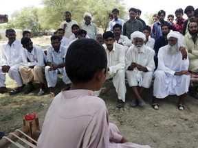 In this picture taken on Aug. 18, 2017, a Pakistani boy who was allegedly raped by a mullah or religious cleric, sits before villagers in Vehari, Pakistan.