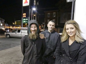 In this Nov. 17, 2017, photo, Johnny Bobbitt Jr., left, Kate McClure, right, and McClure's boyfriend Mark D'Amico pose at a Citgo station in Philadelphia. (Elizabeth Robertson/The Philadelphia Inquirer via AP)