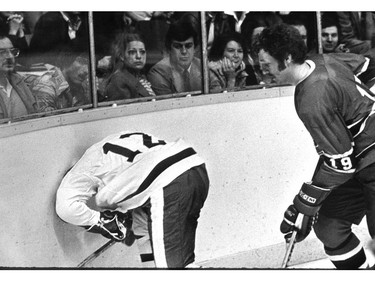 PEAKE ARCHIVES: 1970s. Toronto Maple Leaf Erroll Thompson is hit into the boards by Larry Robinson in an NHL game well before ads on boards.