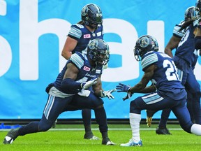 Terrance Plummer (left) celebrates his interception return for a TD in the first quarter yesterday. Stan Behal/Toronto Sun/Postmedia Network