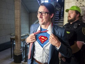 Prime Minister Justin Trudeau shows off his costume as Clark Kent, alter ego of comic book superhero Superman, as he walks through the House of Commons, in Ottawa on October 31, 2017. (Adrian Wyld/THE CANADIAN PRESS)