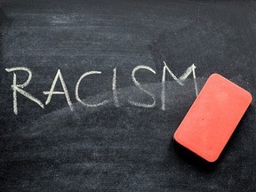 erasing racism, hand written word on blackboard being erased concept