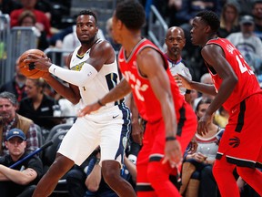 Denver Nuggets forward Paul Millsap, back left, looks to pass the ball as Toronto Raptors guard DeMar DeRozan, front, and forward Pascal Siakam, of Cameroon, defend in the first half of an NBA basketball game Wednesday, Nov. 1, 2017, in Denver. (AP Photo/David Zalubowski)