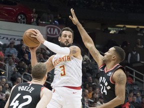 Atlanta Hawks guard Marco Belinelli (3) goes high to pass while Toronto Raptors center Jakob Poeltl (42), of Austria, and forward Norman Powell (24) defend during the first half of a NBA basketball game, Saturday, Nov. 25, 2017, in Atlanta. THE ASSOCIATED PRESS