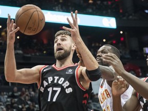 Toronto Raptors center Jonas Valanciunas (17), of Lithuania, vies for a rebound with Atlanta Hawks center Dewayne Dedmon and forward OG Anunoby (3), of England, during the second half of a NBA basketball game, Saturday, Nov. 25, 2017, in Atlanta. THE ASSOCIATED PRESS