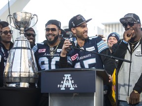 Argonauts quarterback Ricky Ray looks over at James Wilder Jr. as he speaks to fans gathered in Nathan Phillips Square on Nov. 28, 2017