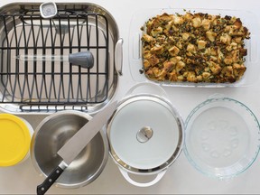 This Oct. 16, 2017 photo provided by Katie Workman shows some must have Thanksgiving tools in New York. Pictured are a roasting oasting pan with rack, baster, instant thermometer, glass baking dish, glass pie plate, casserole pot, mixing bowl, chef's knife and storage containers. (Sarah Crowder/Katie Workman via AP)