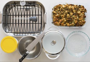 This Oct. 16, 2017 photo provided by Katie Workman shows some must have Thanksgiving tools in New York. Pictured are a roasting oasting pan with rack, baster, instant thermometer, glass baking dish, glass pie plate, casserole pot, mixing bowl, chef's knife and storage containers. (Sarah Crowder/Katie Workman via AP)