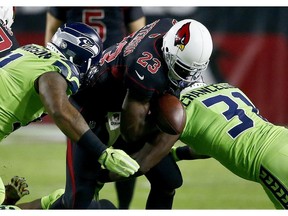 Arizona Cardinals running back Adrian Peterson (23) fumbles the football as Seattle Seahawks strong safety Kam Chancellor (31) and defensive tackle Sheldon Richardson make the hit during the first half of an NFL football game, Thursday, Nov. 9, 2017, in Glendale, Ariz. The Seahawks recovered the ball. (AP Photo/Ross D. Franklin)