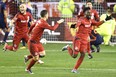 Toronto FC forward Tosaint Ricketts (87), right to left, celebrates his goal with teammates Will Johnson (7) and Michael Bradley (4) during second half MLS soccer playoff action against New York City FC in Toronto, Sunday, October 30, 2016. THE CANADIAN PRESS/Frank Gunn