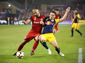 Toronto FC's Victor Vazquez, left, fights for the ball against New York Red Bulls' Connor Lade during second half MLS soccer action Saturday September 30, 2017 in Toronto. THE CANADIAN PRESS/Jon Blacker