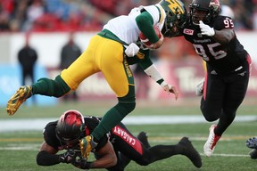 Edmonton Eskimos Mike Reilly is tackled by Jameer Thurman and Ja'Gared Davis of the Calgary Stampeders during the 2017 CFL Western Final in Calgary on Sunday. (Al Charest/Postmedia)