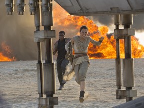 This photo provided by Disney/Lucasfilm shows Daisy Ridley, right, as Rey, and John Boyega as Finn, in a scene from the film, "Star Wars: The Force Awakens," directed by J.J. Abrams. (David James/Disney/Lucasfilm)