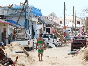 A woman walks along damaged Grande Case, St. Maarten days after the Caribbean island sustained extensive damage during Hurricane Irma on September 12, 2017.