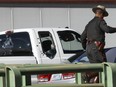 A Rhode Island State policeman walks past a white pickup truck with multiple bullet holes in the windows and right side at the scene of a shooting on Interstate 95 in Providence, R.I., Thursday, Nov. 9, 2017.