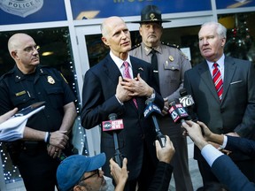 Florida Gov. Rick Scott, centre, with Tampa Police Chief Brian Dugan, left, and Tampa Mayor Bob Buckhorn, right, talks with members of the media at Tampa Police Headquarters Wednesday, Nov. 29, 2017.