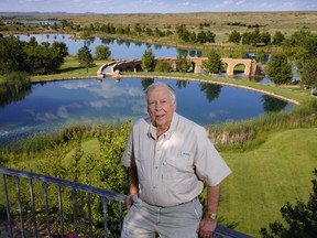 This photo taken May 30, 2017, shows businessman T. Boone Pickens posing for a photo before a series of man-made lakes leading from The Lake House to The Lodge on his Mesa Vista Ranch in the panhandle of Texas.