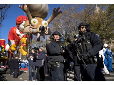 Heavily-armed members of the New York Police Department take a position along the route before the start of the Macy's Thanksgiving Day Parade in New York, Thursday, Nov. 23, 2017. (AP Photo/Craig Ruttle)
