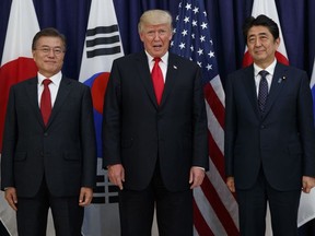 In this July 6, 2017 file photo, President Donald Trump meets with Japanese Prime Minister Shinzo Abe, right, and South Korean President Moon Jae-in before the Northeast Asia Security dinner at the US Consulate General in Hamburg.