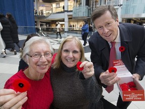 Marguerite Lewis and Alice Repack happily receive a poppy from Toronto Mayor John Tory on Thursday, November 9, 2017.