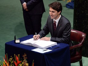 Prime Minister Justin Trudeau signs the Paris Agreement on climate change during a ceremony at the United Nations headquarters in New York on Friday, April 22, 2016.