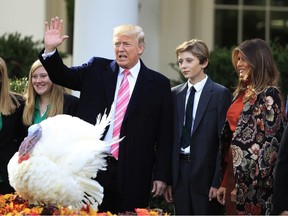 President Donald Trump with first lady Melania Trump, right, and their son Barron Trump, waves after pardoning the National Thanksgiving Turkey Drumstick during a ceremony in the Rose Garden of the White House in Washington, Tuesday, Nov. 21, 2017. This is the 70th anniversary of the National Thanksgiving Turkey presentation.