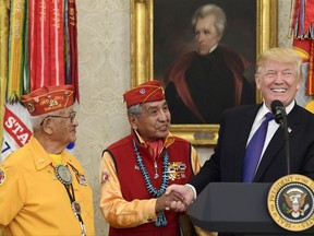 President Donald Trump, right, meets with Navajo Code Talkers Peter MacDonald, center, and Thomas Begay, left, in the Oval Office of the White House in Washington, Monday, Nov. 27, 2017.