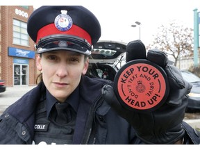 York Region police constable Laura Nicolle shows one of the pucks they are handing out to motorists as part of their new distracted driving program that nabbed drivers in Richmond Hill for the media on Wednesday on Wednesday November 22, 2017.