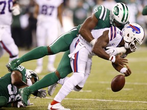 Bills quarterback Tyrod Taylor, bottom, fumbles the ball as he is hit by Jets outside linebacker Jordan Jenkins (48) during NFL action Thursday, Nov. 2, 2017, in East Rutherford, N.J. (Kathy Willens/AP Photo)