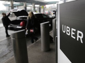 In this March 15, 2017, file photo, a sign marks a pick up point for the Uber car service at LaGuardia Airport in New York.