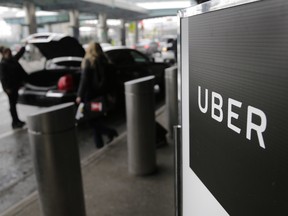 In this March 15, 2017, file photo, a sign marks a pick-up point for the Uber car service at LaGuardia Airport in New York. Uber is coming clean about its cover-up of a year-old hacking attack that stole personal information about more than 57 million of the beleaguered ride-hailing service's customers and drivers. The revelation Tuesday marks the latest stain on Uber's reputation. (AP Photo/Seth Wenig, File)