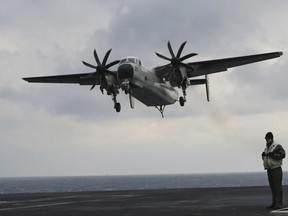 FILE - In this March 14, 2017, file photo, a U.S. Navy C-2 Greyhound approaches the deck of the Nimitz-class aircraft carrier USS Carl Vinson during the annual joint military exercise called Foal Eagle between South Korea and the United States at an unidentified location in the international waters, east of the Korean Peninsula. A similar type of the U.S. Navy plane carrying 11 crew and passengers crashed into the Pacific Ocean on Wednesday, Nov. 22, 2017, while on the way to the USS Ronald Reagan aircraft carrier, the Navy said. (AP Photo/Lee Jin-man, File)