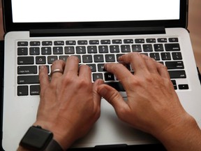 A person works on a laptop in North Andover, Mass., June 19, 2017 file photo. More members of the workforce are cramming the country's buses, subways and highways each day, adding precious minutes to the daily commute, Statistics Canada reported Wednesday in its sixth and final batch of numbers from the 2016 census. THE CANADIAN PRESS/AP/Elise Amendola