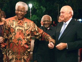 File photo of former South African presidents Nelson Mandela, left, and FW de Klerk, right, with Anglican Archbishop Desmond Tutu, center, at de Klerk's 70th birthday party in Cape Town, South Africa, in 2014.