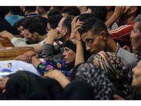 Relatives of killed Coptic Christians grieve by the coffins during the funeral at Abu Garnous Cathedral in the north Minya town of Maghagha, on May 26, 2017.   Egypt launched an air strike on a jihadist training camp after masked gunmen attacked a bus of Coptic Christians south of the Egyptian capital, killing at least 28 people.
