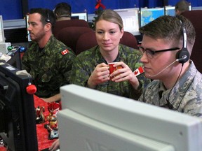 Cpl. Andrew Steeves, left, Lt. Sally Riendeau and Senior Airman Cody Berry man the monitors at 21 Aerospace Control and Warning Squadron at 22 Wing/CFB North Bay, Thursday. Charlie Flight of the squadron will be on duty Christmas Eve as Norad personnel track Santa's flight through the skies. (PJ Wilson/Postmedia Network)