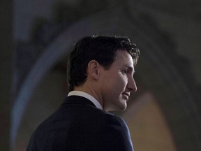 Prime Minister Justin Trudeau listens to a question from the media in the foyer of the House of Commons following the release of an ethics report in Ottawa on December 20, 2017.