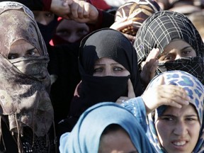 Syrian refugees wait to cross from Syria into Jordan last year.