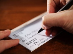 Writing a donation check to a charitable organization. (Getty Images)