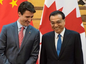 Canada's Prime Minister Justin Trudeau (L) and China's Premier Li Keqiang smile during a signing ceremony at the Great Hall of the People in Beijing on December 4, 2017.