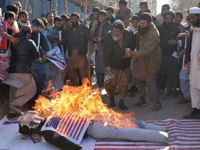 Protesters burn an effigy depicting President Donald Trump during an anti-U.S. and Israeli protest in Quetta on December 7, 2017 following Trump's decision to officially recognise Jerusalem as the Israeli capital.