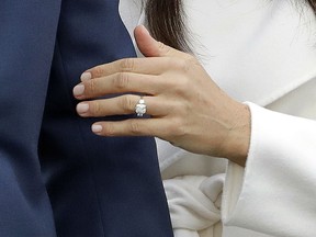 FILE - In this Monday, Nov. 27, 2017 file photo, Britain's Prince Harry's fiancee Meghan Markle shows off her engagement ring as she poses for photographers during a photocall in the grounds of Kensington Palace in London. The jewelry maker who worked on the engagement ring Prince Harry gave to Meghan Markle says it's been inundated with requests for replicas_ but it won't be taking any orders for copycat rings, it was reported on Wednesday, Dec. 6, 2017.