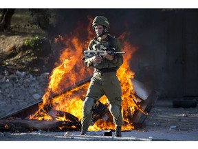 Israeli soldier stands during clashes with Palestinians following a protest against U.S. President Donald Trump's decision to recognize Jerusalem as the capital of Israel in the West Bank City of Nablus, Friday, Dec. 8, 2017.